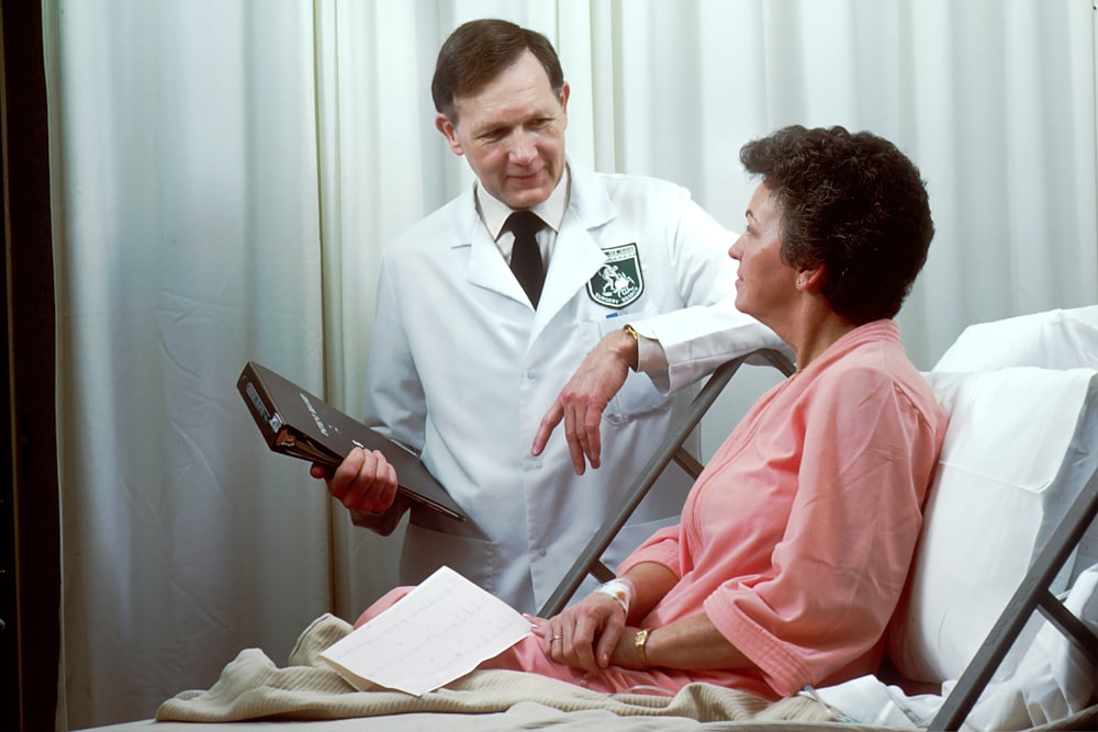 Doctor speaking with an older patient in a hospital room